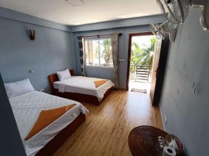 瓜隆岛Roomy Guesthouse的客房设有两张床和窗户。