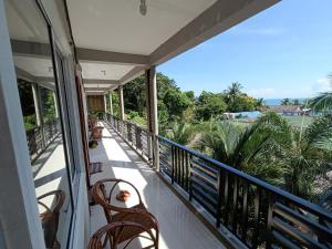 瓜隆岛Roomy Guesthouse的阳台配有椅子,享有海景。