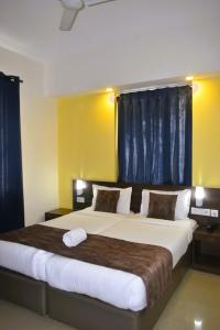 马尔冈Relax Holiday Home,Margao Railway Station的一间卧室设有两张带蓝色窗帘的大床