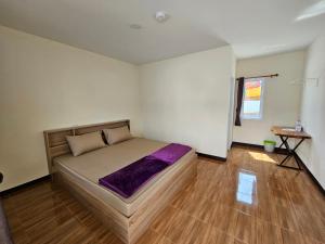 罗勇Klong Zand Resort的一间卧室配有一张床,铺有木地板