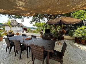 恰卡拉Chacala Corales para 7 con Aire Acondicionado con Alberca y Playa a 50 mts的庭院里配有桌椅和遮阳伞