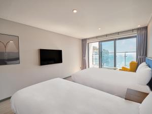 釜山Y Collection by UH FLAT Haeundae beach的酒店客房设有两张床和窗户。