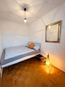 格蒙登Ferienwohnung zum Wohlfühlen的一间卧室配有一张带镜子和灯的床