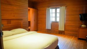 瑟古邦巴塔姆KTM假日酒店的卧室配有白色的床和窗户。