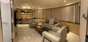 罗东镇米淇旅店 - 罗东馆 的客厅配有沙发、椅子和桌子