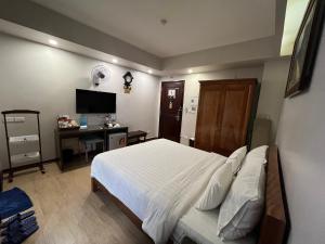 河内A25 Hotel - 88 Nguyễn Khuyến的一间卧室配有一张床、一张书桌和一台电视