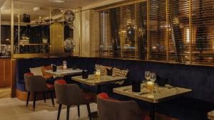 迪拜Millennium Place Dubai Marina的餐厅设有2张桌子和椅子以及窗户。