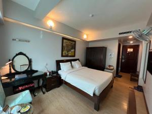 河内A25 Hotel - 88 Nguyễn Khuyến的一间卧室配有一张床、一张书桌和一面镜子
