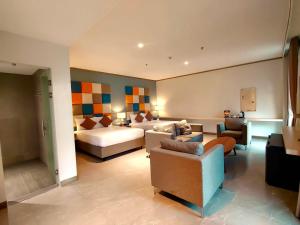 BuliranYes Hotel San Ildefonso Bulacan的酒店客房配有一张床、一张沙发和椅子。