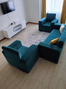 Langata RongaiHome away的客厅配有2张蓝色沙发和电视
