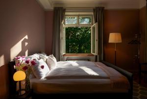 苏黎世Signau House & Garden Boutique Hotel Zürich的卧室在窗户前配有一张大床