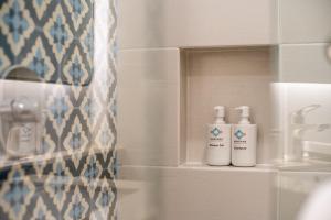 龙目岛库塔MONTANA @OCEANSIDE MANDALIKA的浴室的架子上放着两瓶气味剂