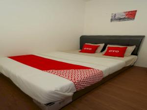雅加达Capital O 93261 Fresh Hotel Near Stasiun Jakarta Kota的床上有两个红色枕头的床