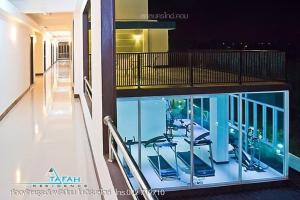 色军ตาฟ้าเรสซิเดนซ์ (Tafah Residence)的一座带游泳池的建筑,阳台上配有椅子
