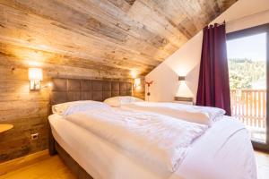 上陶恩Almdorf Hohentauern by ALPS RESORTS的卧室设有两张床铺和木制天花板