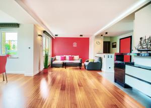 格但斯克Happiness House Balcony & Nice Garden的客厅设有红色的墙壁和沙发