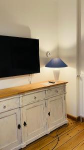 巴特施瓦尔陶gemütliche Wohnung的梳妆台上挂着一盏灯的电视机