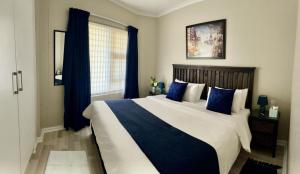 斯特兰德Nautica 403的一间卧室配有一张带蓝色枕头的大床