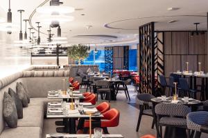 迪拜迪拜瑞汉金玫瑰罗塔纳酒店的一间带桌椅的餐厅