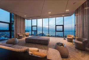 芭堤雅市中心Infinity Pool Ocean View Hotel的带沙发和大窗户的客厅
