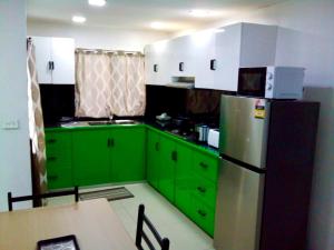 苏瓦HomeStay Private Home的厨房配有绿色橱柜和冰箱。