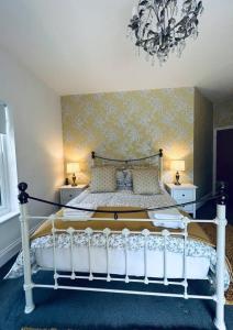 盖茨黑德Stunning 3-Bed Cottage in Gateshead的卧室配有白色床和吊灯