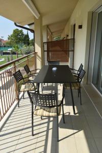 拉齐塞Residence La Magnolia - Aparments的阳台上配有一张黑色的桌子和椅子