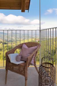 蒙福特达尔巴I Ciabot di Monforte的阳台上的藤椅,书和咖啡杯