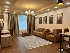 阿拉木图CITY STAY Апарт-Отель Алматы的客厅配有沙发和桌子