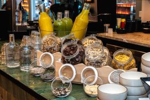 马德里Akeah Hotel Gran Vía的装有玻璃杯和碗的食物和瓶子的柜台