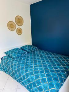 Chennevières-sur-MarneAppartement avec jardin (25min DisneyLand Paris)的卧室内的一张床铺,卧室内有蓝色的墙壁