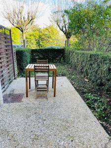 Chennevières-sur-MarneAppartement avec jardin (25min DisneyLand Paris)的人行道上木桌和椅子