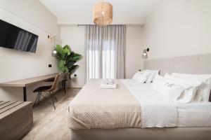 拉加纳斯Manthos Beachfront Apartments的白色卧室配有床和书桌