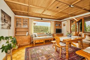 雷特温克尔Alpen-Chalet Benzeck的客厅设有木制天花板和桌子