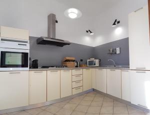 瓦拉泽La Terrazza Apartment,a 50 mt dal mare的厨房配有白色橱柜和水槽