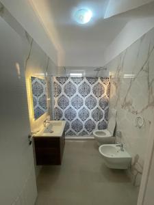 都拉斯Holiday Home的浴室设有2个卫生间和水槽