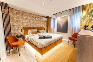 巴勒姆Boetiekhotel Faan - NIEUW!的一间卧室配有一张床和两张橙色椅子