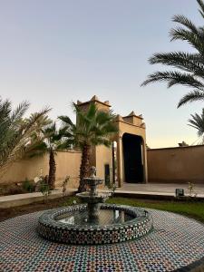 斯库拉Kasbah des cyprès的棕榈树建筑前的喷泉