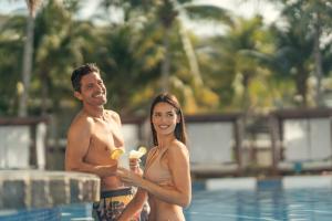 莫雷洛斯港坎昆海滨阿祖尔海滩度假酒店 - 卡利斯玛美食全包的站在游泳池中的男女