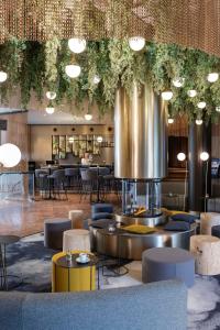 日内瓦NH日内瓦机场酒店的一个带桌椅的大堂和一间餐厅