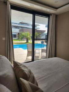 Sere KundaCosta Vista- Standard bedroom flat#501 with private pool- kololi sands的一间卧室配有一张床,享有游泳池的景色