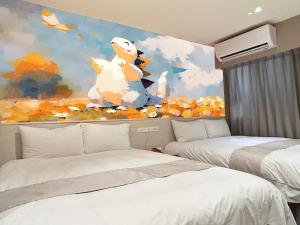 台中市达斯旅店的一间卧室配有两张床和绘画