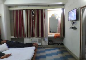 RourkelaHotel Chanderlok Odisha的躺在房间里床上的人