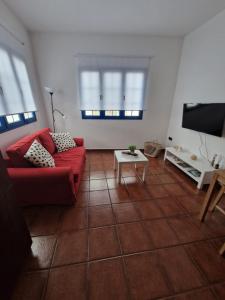 Caleta de CaballoCasa Calandrilla的客厅配有红色沙发和电视