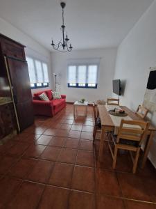 Caleta de CaballoCasa Calandrilla的客厅配有桌子和红色沙发