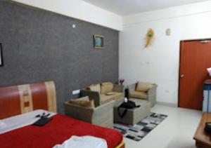 RourkelaHotel Shubham Odisha的一间卧室配有一张床和一张沙发