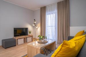 斯克拉斯卡波伦巴RentPlanet - Studio Górna Resorts的客厅配有黄色沙发和电视