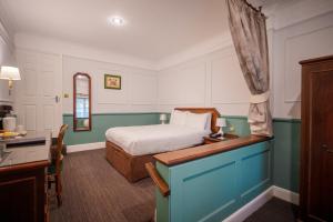 布伦特伍德玛丽格林庄园酒店的一间卧室配有一张床和一张书桌
