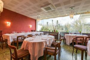 La Pobla de Claramunt罗伯特酒店的用餐室配有桌椅和白色的桌布