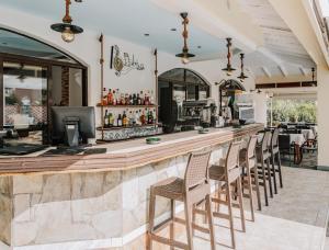 古维亚马尔泰佐斯酒店的餐厅内的酒吧,配有桌椅